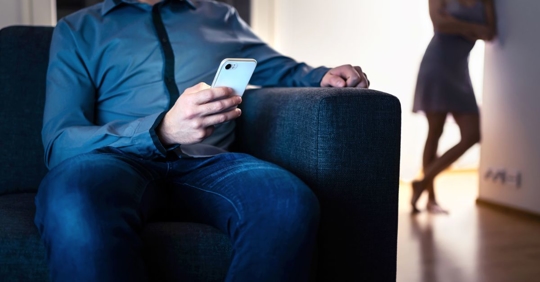 Man on phone with woman behind him