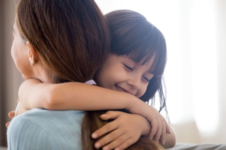 Close up of cute little girl hugging mom